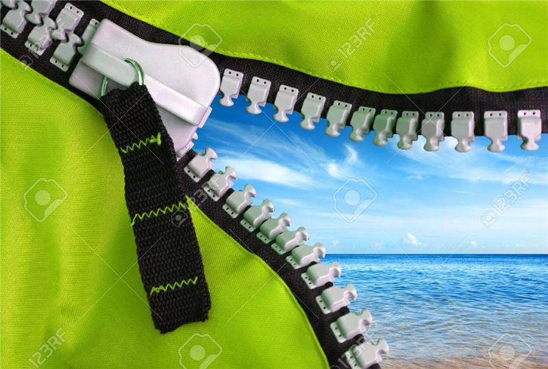 Open zipper of a camping tent showing a beautiful blue sky and clear sea Stock Photo